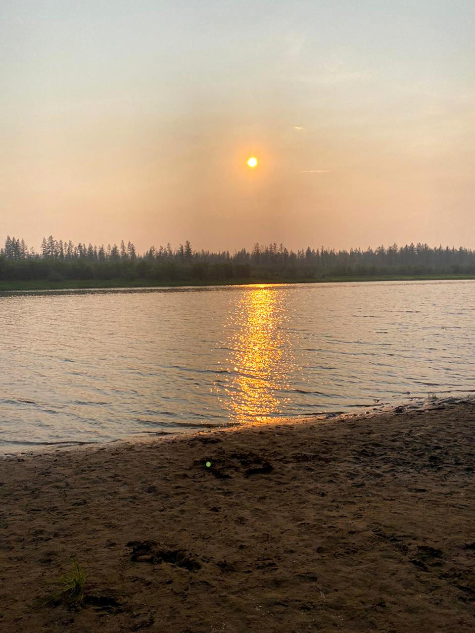 In this handout photo taken Tuesday, June 23, 2020 and provided by Olga Burtseva, a beach on the bank of Yana river is empty due to hot weather, during sunset outside Verkhoyansk, the Sakha Republic, about 4660 kilometers (2900 miles) northeast of Moscow, Russia. A record-breaking temperature of 38 degrees Celsius (100.4 degrees Fahrenheit) was registered in the Arctic town of Verkhoyansk on Saturday, June 20 in a prolonged heatwave that has alarmed scientists around the world. (Olga Burtseva via AP)