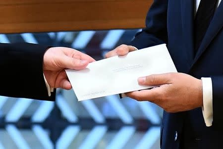 A detail show Britain's permanent representative to the European Union Tim Barrow (L) who delivers British Prime Minister Theresa May's Brexit letter in notice of the UK's intention to leave the bloc under Article 50 of the EU's Lisbon Treaty to EU Council President Donald Tusk in Brussels, Belgium, March 29, 2017. REUTERS/Emmanuel Dunand/Pool