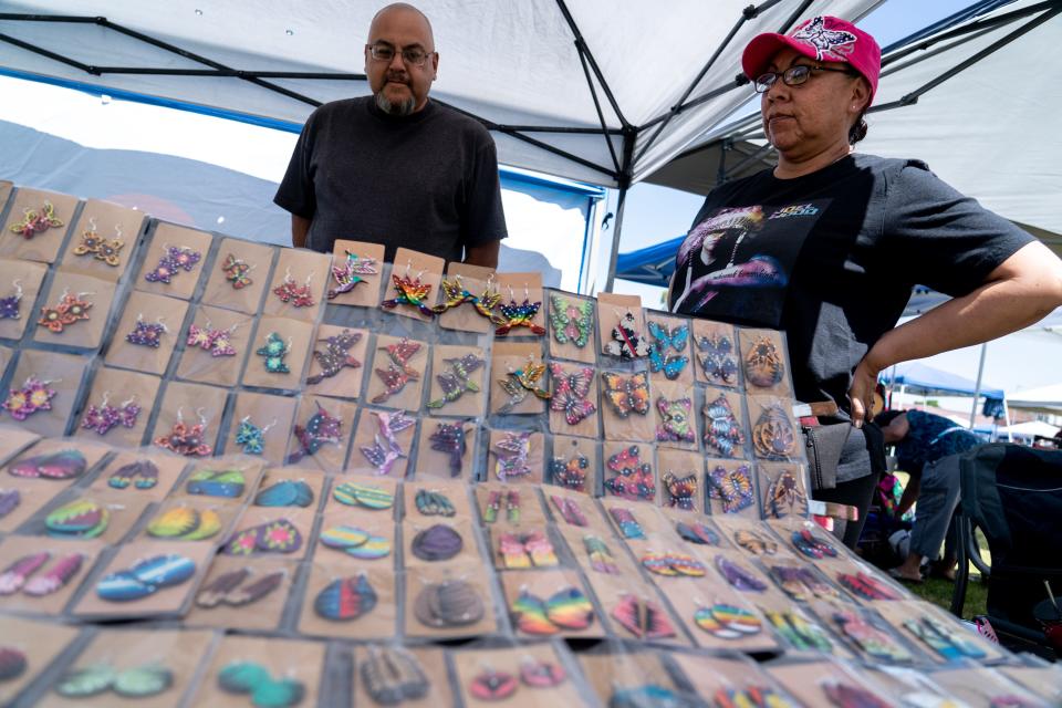 Ray Benavidez, left, and his wife Mika "Butterfly" Carroll, of the Navajo Nation, right, display their jewelry from Butterfly's Creations during the 3rd Annual Two Spirit Powwow at South Mountain Community College in Phoenix on April 15, 2023.
