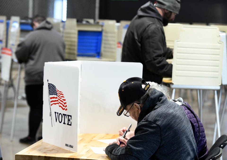 George Struchynski and his wife, Rita, share a voting booth as they fill in their ballots in Bismarck, North Dakota, Tuesday, Nov. 8, 2022. (Mike McCleary/The Bismarck Tribune via AP)