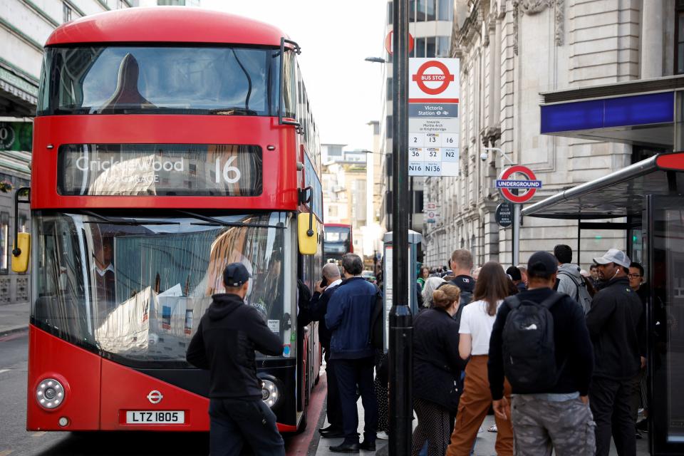 People board bus outside Victoria Station (REUTERS)