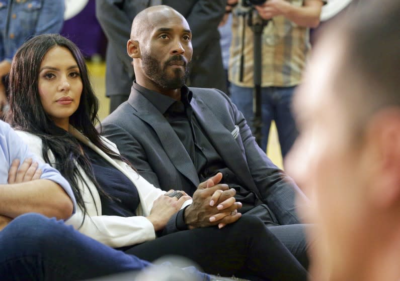 Kobe Bryant and his wife, Vanessa, watch as Rob Pelinka, right, speaks March 10, 2017.