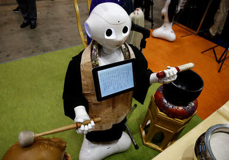 A 'robot priest' wearing a Buddhist robe chants sutras at it beats a wooden fish during its demonstration at Life Ending Industry EXPO 2017 in Tokyo, Japan August 23, 2017. REUTERS/Kim Kyung-Hoon