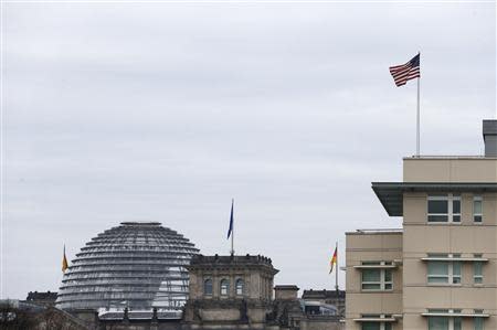 A U.S. flag flies atop the U.S.embassy next to the Reichstag building, seat of the German lower house of parliament Bundestag, in Berlin October 25, 2013. REUTERS/Tobias Schwarz