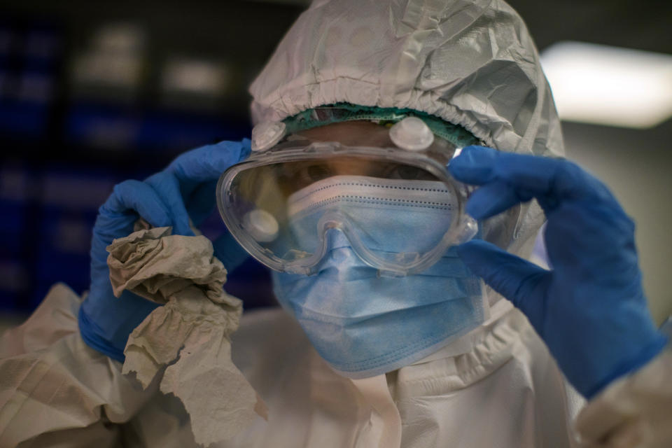 ARCHIVO - En esta imagen del martes 14 de julio de 2020, una trabajadora sanitaria se ajusta las gafas de protección antes de tomar muestras para una prueba PCR de COVID-19 en un hospital local de Hospitalet, a las afueras de Barcelona, en España. El virus está repuntando en algunas partes de España, y parece que Cataluña y otras regiones no están adecuadamente preparadas para rastrear los nuevos contagios, lo que se supone debería ser un sistema de detección temprana para frenar los nuevos brotes e impedir una nueva oleada de casos. (AP Foto/Emilio Morenatti, Archivo)