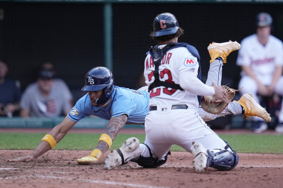 Tampa Bay Rays' Jose Siri, left, slide into home plate in front of Cleveland Guardians catcher Bo Naylor, right, to score in the eighth inning of a baseball game, Sunday, Sept. 3, 2023, in Cleveland. (AP Photo/Sue Ogrocki)