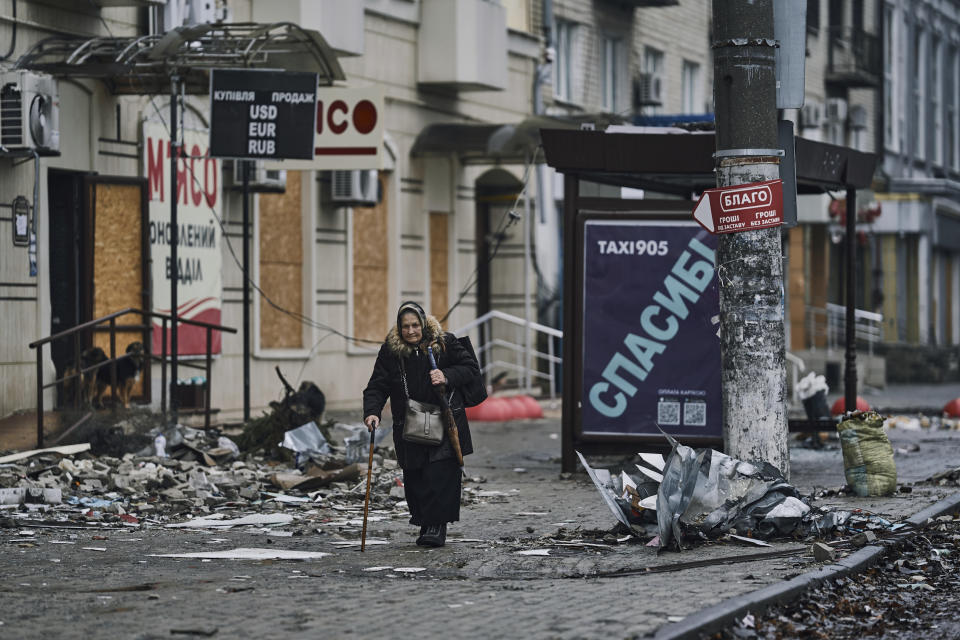 FILE - A local resident walks along a street in Bakhmut, in the Donetsk region, Ukraine, Saturday, Dec. 17, 2022. (AP Photo/LIBKOS, File)