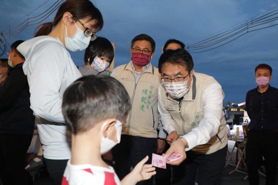 台南市長黃偉哲到新永華夜市參加首場銅板快閃夠購go活動，將夜市券發放給排隊民眾。（新聞處提供）