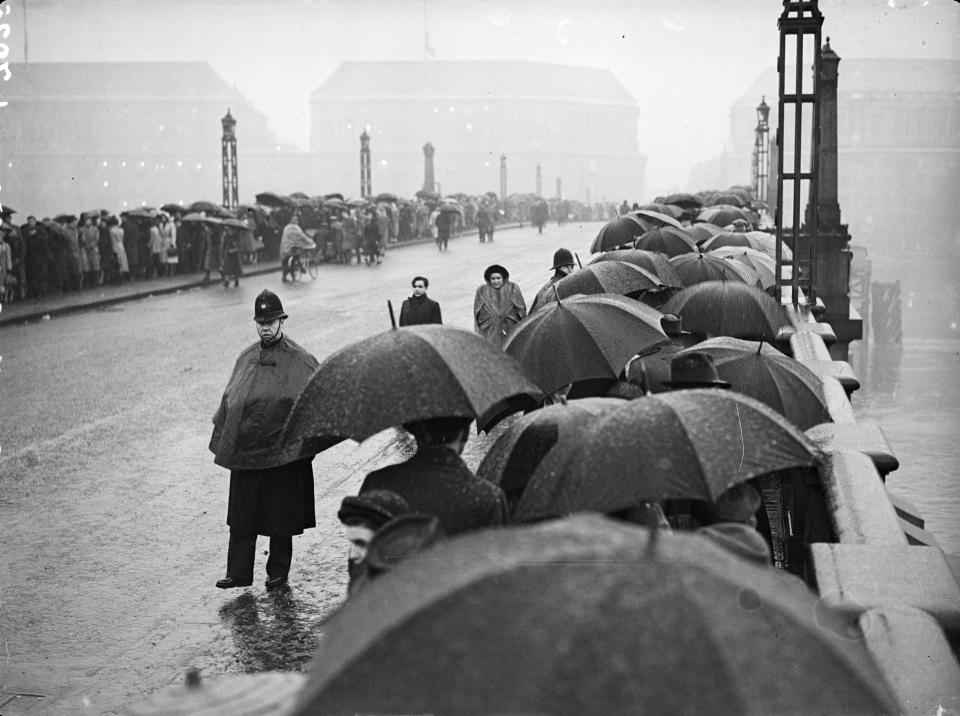February 1952:  Policemen organise the crowds of people queuing to view King George VI lying in state at Westminster Hall. The line stretched across Lambeth Bridge down to Albert Embankment and Westminster Bridge, where it turned back on itself.  (Photo by Evening Standard/Getty Images)
