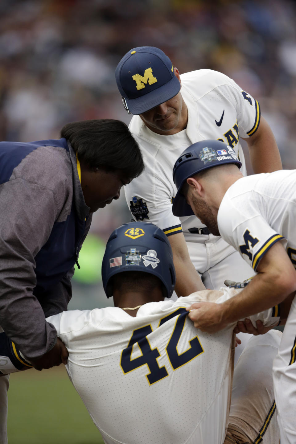 Michigan designated hitter Jordan Nwogu (42) is helped of the field after being injured trying to reach first base against Vanderbilt in the third inning of Game 2 of the NCAA College World Series baseball finals in Omaha, Neb., Tuesday, June 25, 2019. (AP Photo/Nati Harnik)