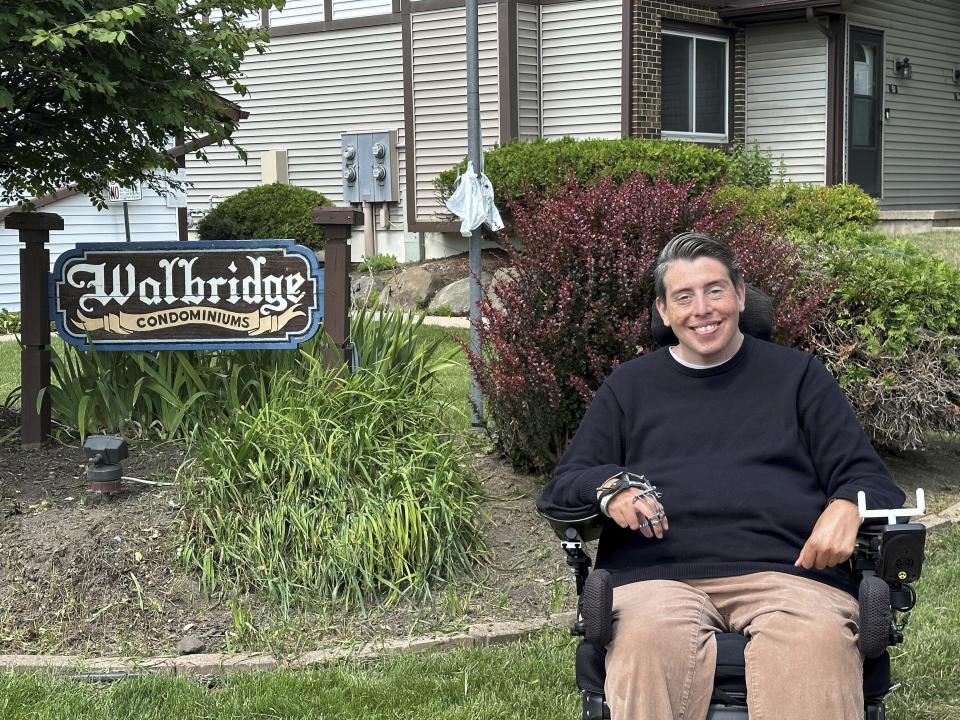 Wisconsin state Rep. Jimmy Anderson poses, Thursday, Aug. 10, 2023, in Madison, Wis., outside of a condominium complex that is disconnected from the rest of his legislative district. A lawsuit contends that such disconnected sections of land violate the state constitution and that the current districts should be redrawn before the 2024 election. (AP Photo/Scott Bauer)