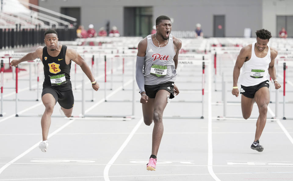 This photo provided by Pittsburg State Athletics shows Pittsburg State hurdler Cordell Tinch, center, reacting after competing against British hurdler Tade Ojora of USC, left, and Louis Rollins in the 110m hurdles final at the Arkansas Grand Prix athletics event in Fayetteville, Ark., June 23, 2023. (Shawn Price/Pittsburg State via AP)