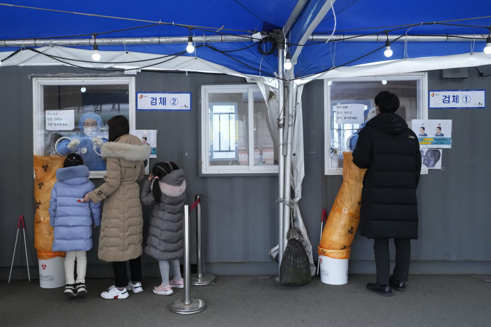 Medical workers take nasal samples from people at a makeshift coronavirus testing site in Seoul, South Korea, Tuesday, Dec, 14, 2021. (AP Photo/Ahn Young-joon)