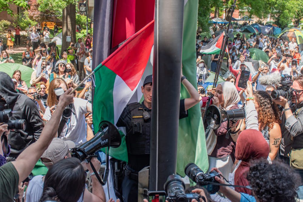 A George Washington University police officer lowers a large Palestinian flag that had been raised by student demonstrators in violation of university policy in Washington, D.C., on May 2.<span class="copyright">Kaiden J. Yu for The GW Hatchet</span>