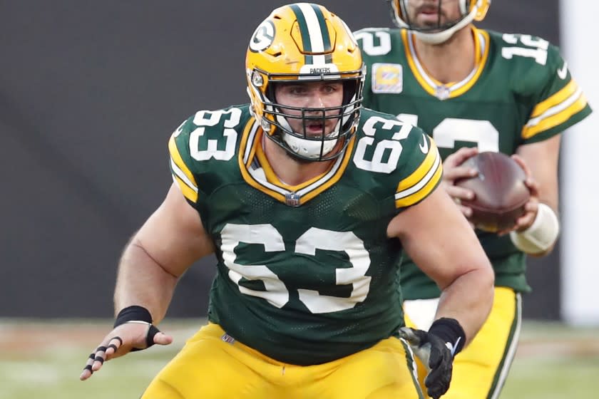 FILE - Green Bay Packers center Corey Linsley (63) blocks for quarterback Aaron Rodgers.