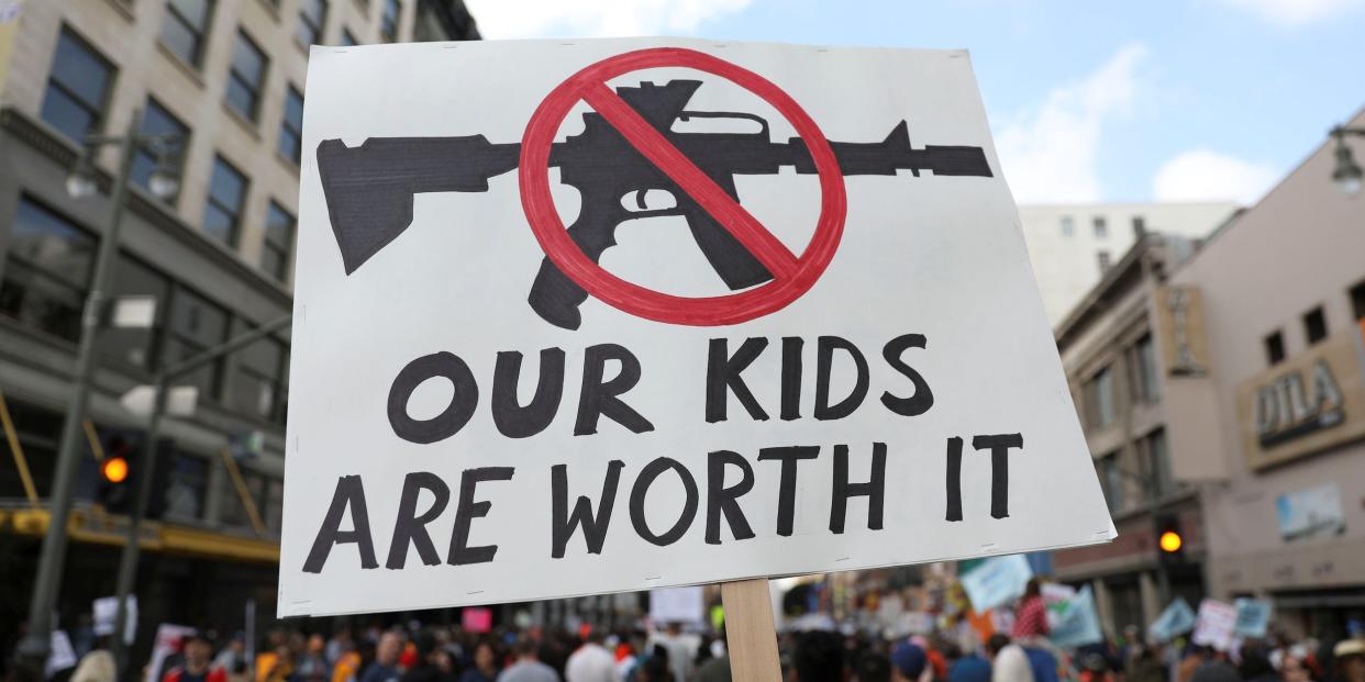 People walk with signs against assault rifles during "March for Our Lives", an organized demonstration to end gun violence, in downtown Los Angeles, California, U.S., March 24, 2018.