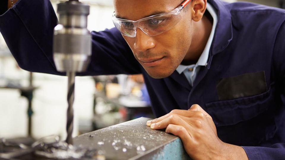 Close Up Of Apprentice Engineer Using Milling Machine.