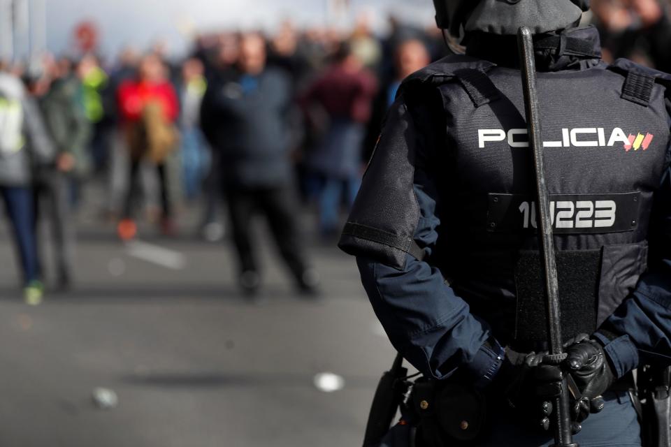 <p>Un agente antidisturbio vigila a los manifestantes. (Foto: Chema Moya / EFE). </p>