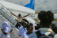 A police officer tries to block Haitians deported from the United States from boarding the same plane they were deported on, in an attempt to return to the United States, on the tarmac of the Toussaint Louverture airport, in Port-au-Prince, Haiti, Tuesday, Sept. 21, 2021 (AP Photo/Joseph Odelyn)