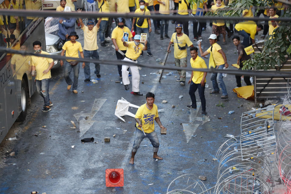 Royalist supporters look to confront pro-democracy protesters during an anti-government rally near the Parliament in Bangkok, Tuesday, Nov. 17, 2020. Thailand's political battleground shifted to the country's Parliament Tuesday, where lawmakers are considering proposals to amend the country's constitution, one of the core demands of the student-led pro-democracy movement. (AP Photo/Sakchai Lalit)