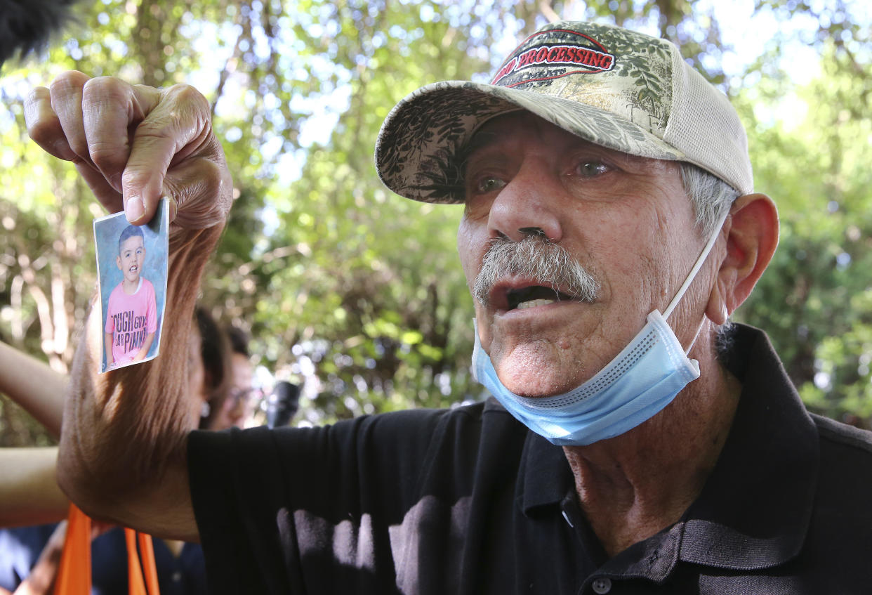 George Rodriguez holds up a picture of his grandson, Jose Flores, Jr., one of victims in Tuesday's shootings at Robb Elementary School, Thursday, May 26, 2022, in Uvalde, Texas. (Kin Man Hui/The San Antonio Express-News via AP)