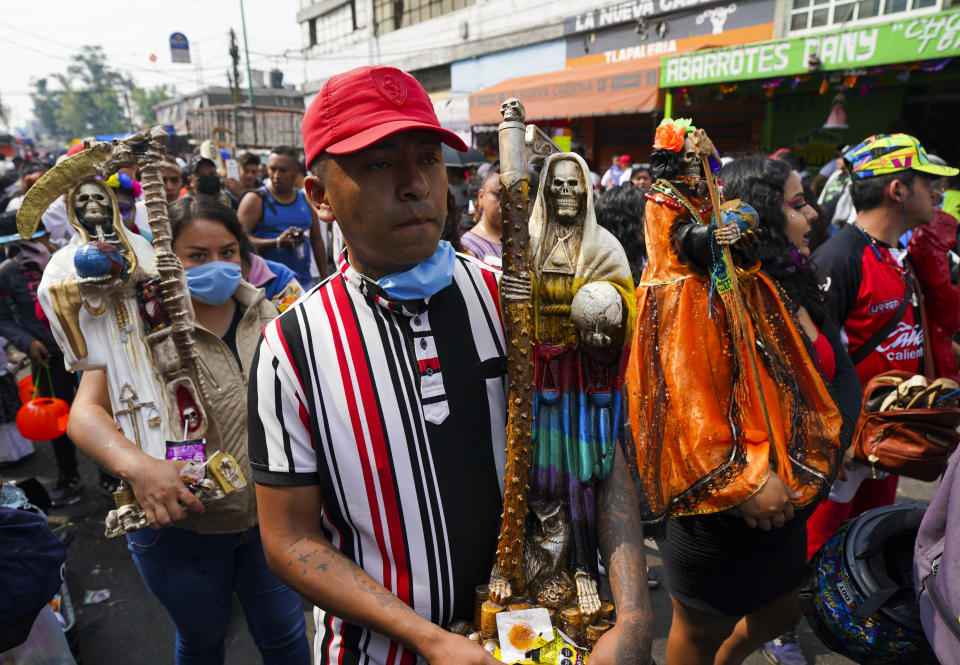 Devotos cargan estatuas ornamentadas de "La Santa Muerte", en el barrio de Tepito de la Ciudad de México, el martes 1 de noviembre de 2022. La Santa Muerte es una imagen de culto y un santo popular, una personificación de la muerte, asociada con la curación, la protección y la entrega segura al más allá por parte de sus devotos. (AP Foto/Fernando Llano)