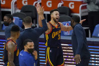 Golden State Warriors guard Stephen Curry, middle, celebrates after scoring against the Miami Heat during overtime in an NBA basketball game in San Francisco, Wednesday, Feb. 17, 2021. (AP Photo/Jeff Chiu)