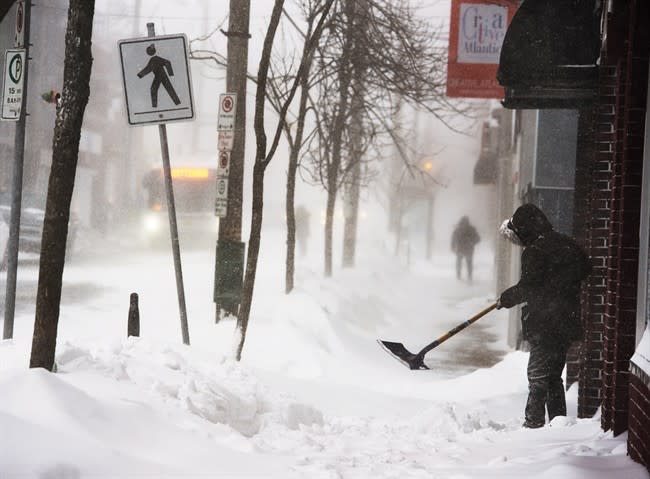 A man clears a sidewalk in blizzard conditions in Halifax on Friday, Jan. 3, 2014. The region is in the grip of unseasonably cold temperatures with heavy snow and high winds. THE CANADIAN PRESS/Andrew Vaughan