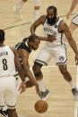 Milwaukee Bucks forward Khris Middleton, center, drives against Brooklyn Nets guard James Harden, right, during the first half of Game 6 of a second-round NBA basketball playoff series Thursday, June 17, 2021, in Milwaukee. (AP Photo/Jeffrey Phelps)