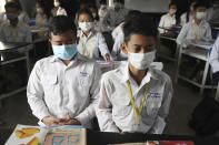 Students wearing masks meditate prior to a lesson at a high school in Phnom Penh, Cambodia, Tuesday, Jan. 28, 2020. China on Tuesday reported 25 more deaths from a new viral disease, as the U.S. government prepared to fly Americans out of the city at the center of the outbreak. (AP Photo/Heng Sinith)