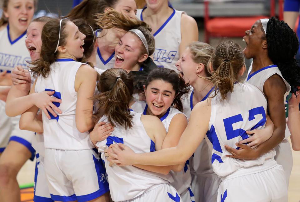 Assumption players rush the court to celebrate their victory against McDonell Central Catholic during their WIAA Division 5 state semifinal game Friday at the Resch Center in Ashwaubenon.
