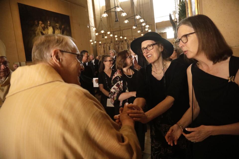 Msgr. Lloyd Torgerson, left, pastor at St. Monica Catholic Church, greets members of Richard Riordan's family.