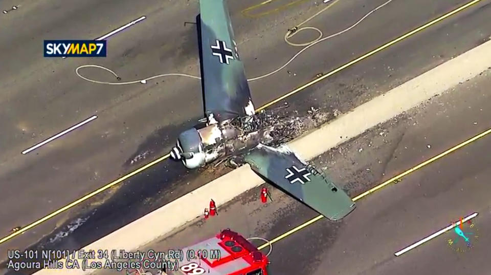 This photo taken from video provided by KABC-TV shows a vintage North American AT-6 airplane that crashed on U.S. 101 in Agoura Hills, Calif., Tuesday, Oct. 23, 2018. The pilot escaped uninjured and no one on the ground was hurt. The crash snarled traffic about 30 miles (50 kilometers) west of downtown Los Angeles. (KABC-TV via AP)