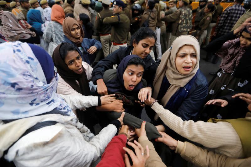 Police detain a student outside Jamia Millia Islamia University during a protest against the Citizenship Amendment Bill in New Delhi