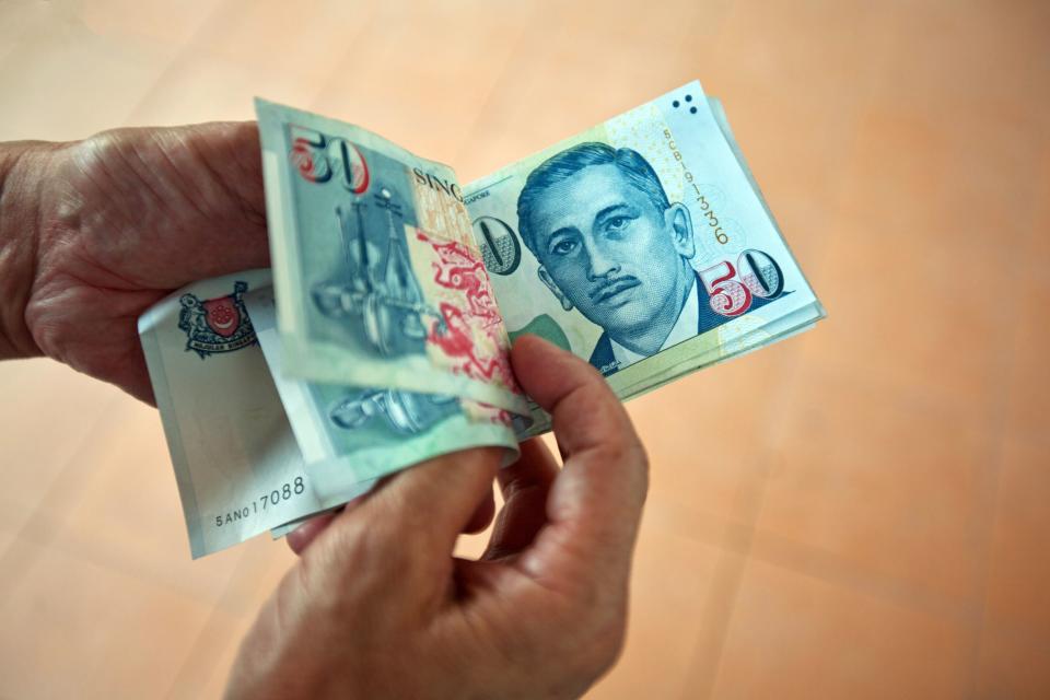 Singapore dollar banknotes are arranged for a photograph in Singapore on Saturday, April 9, 2016.  