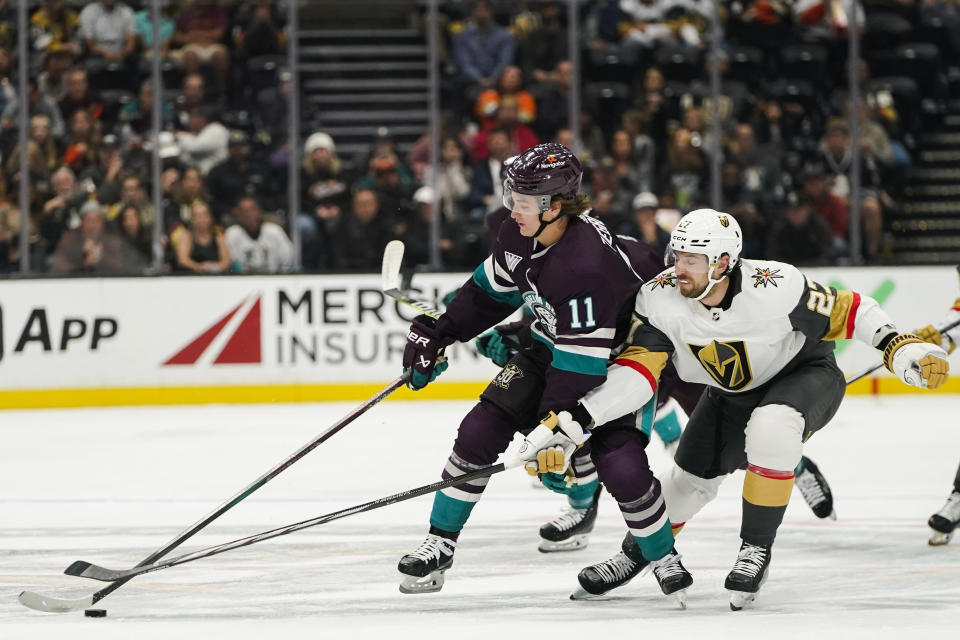 Anaheim Ducks center Trevor Zegras, left, and Vegas Golden Knights defenseman Shea Theodore vie for the puck during the first period of an NHL hockey game Sunday, Nov. 5, 2023, in Anaheim, Calif. (AP Photo/Ryan Sun)