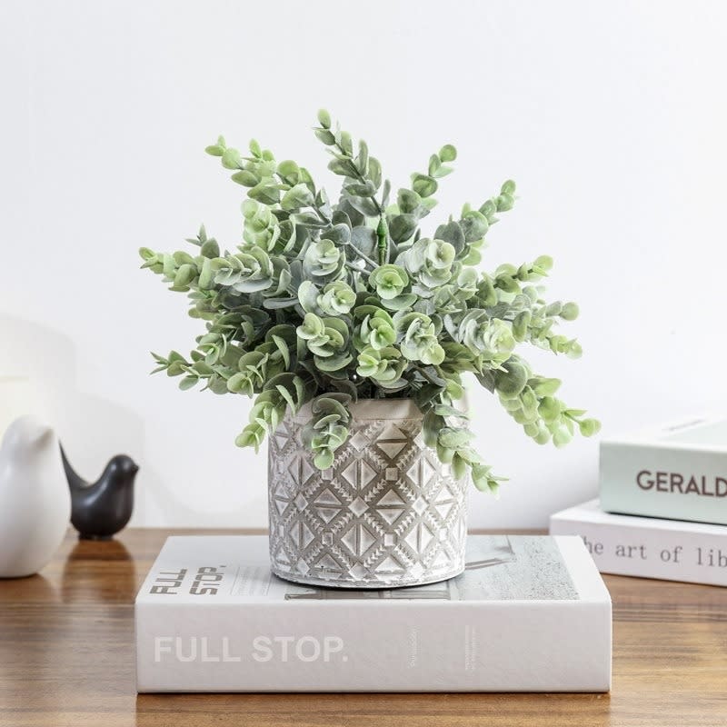 the faux eucalyptus plant in a ceramic pot on a table