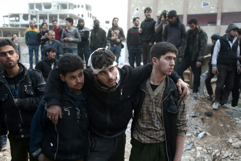 Syrians gather as they prepare to board buses to evacuate one of the few remaining rebel-held pockets in Eastern Ghouta, on the outskirts of the Syrian capital Damascus, on March 24