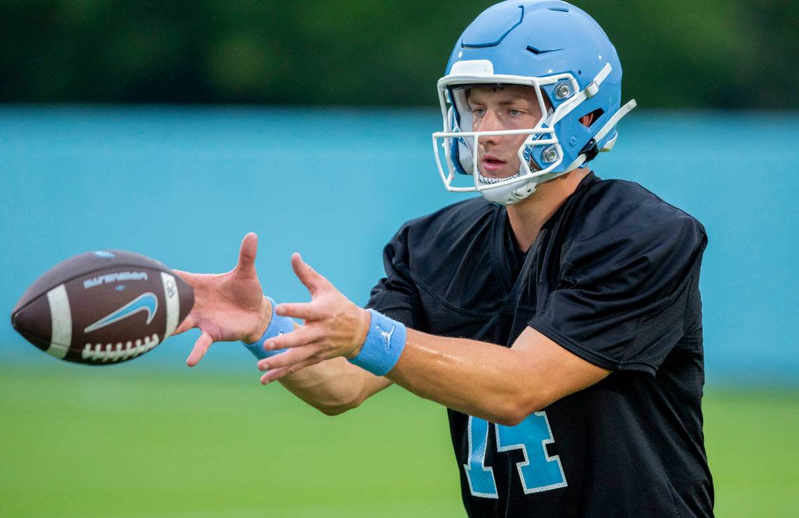 North Carolina graduate transfer quarterback Max Johnson (14) takes a snap during the Tar Heels’ first practice of the season on Monday, July 29, 2024 in Chapel Hill, N.C.