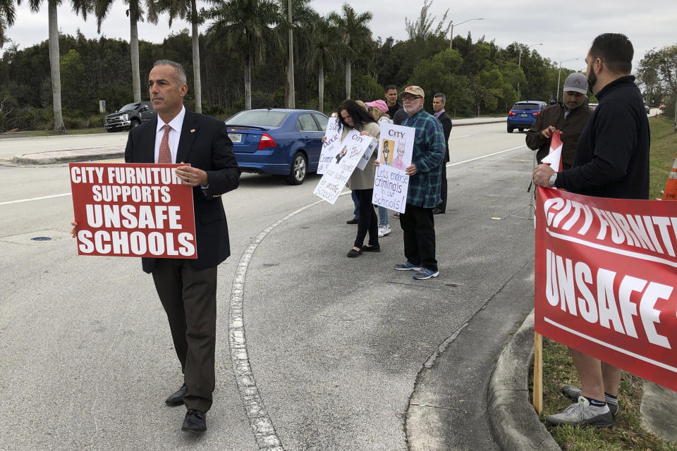 FILE - Andrew Pollack, whose daughter Meadow was killed in the Marjory Stoneman Douglas High School massacre, leads a protest outside City Furniture's headquarters in Tamarac, Fla., Monday, Jan. 28, 2019. The parents of some victims of the Florida high school massacre are protesting the furniture company whose CEO supports the local school superintendent. (AP Photo/Terry Spencer, File)