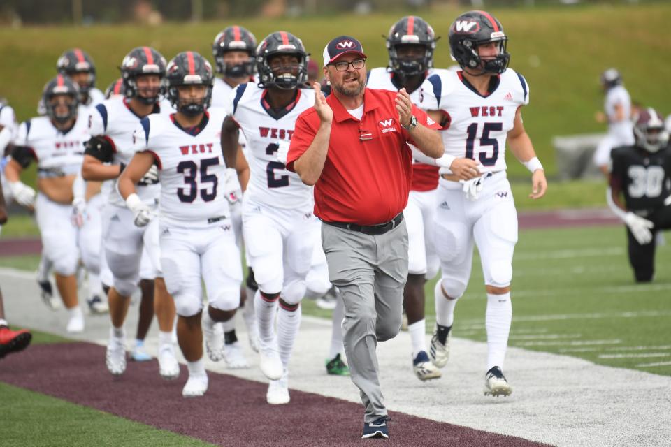 Coach Brown runs out with his players before the game at Bearden on Aug. 20.