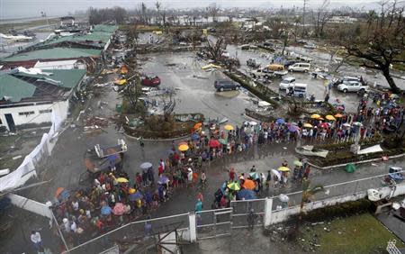 Typhoon victims queue for food and water outside an airport after Super Typhoon Haiyan battered Tacloban city in central Philippines November 10, 2013. REUTERS/Erik De Castro