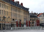 A man walks in the main square in Lille, northern France, Sunday March 15, 2020. French Prime Minister Edouard Philippe announced that France is shutting down all restaurants, cafes, cinemas and non-essential retail shops, starting Sunday, to combat the accelerated spread of the virus in the country. For most people, the new coronavirus causes only mild or moderate symptoms. For some it can cause more severe illness. (AP Photo/Michel Spingler)