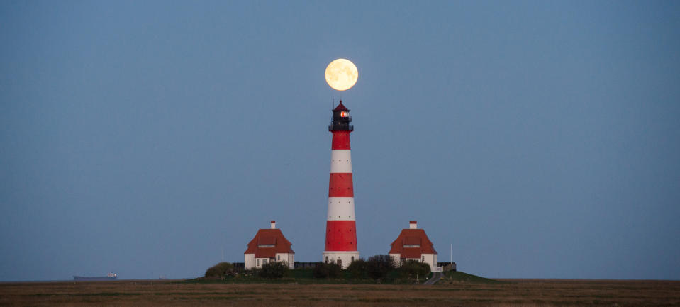 <p>Der Mond steht am 21. April scheinbar über dem Leuchtturm in Westerhever in Schleswig-Holstein. (Bild: dpa) </p>