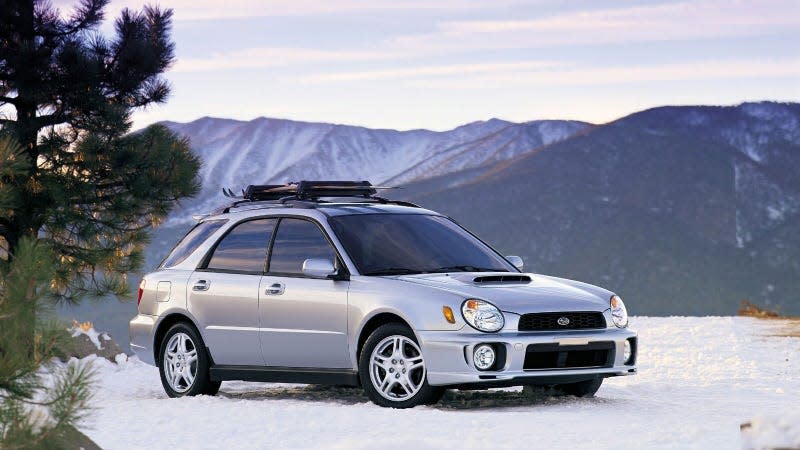 A photo of a silver Subaru WRX Wagon on the snow. 