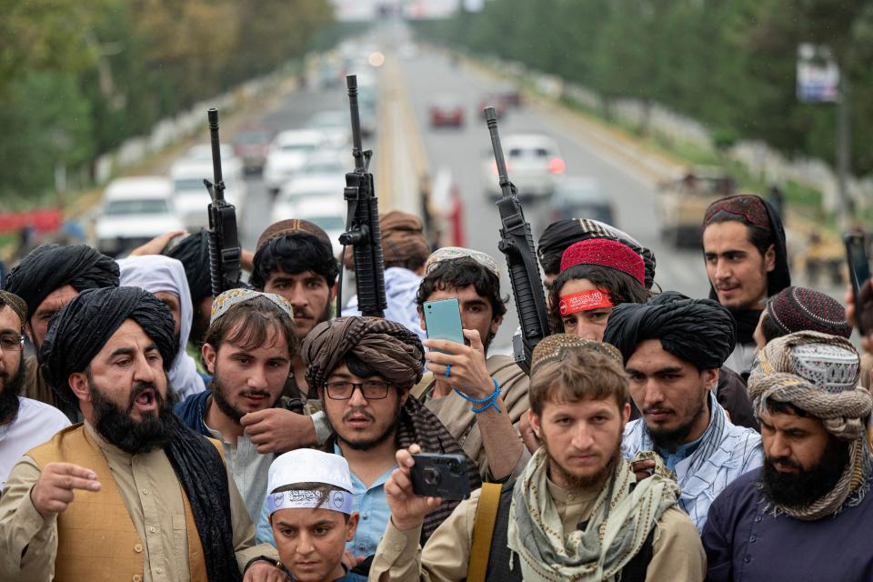 Taliban fighters hold rifles as they chant victory slogans at the Ahmad Shah Massoud Square in Kabul on August 15, 2022.