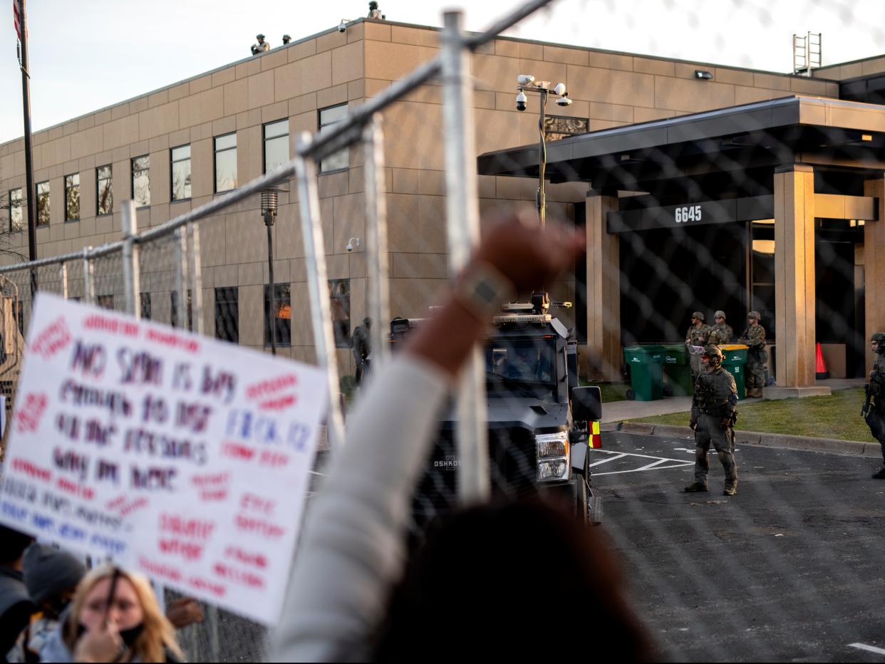 <p>Police officers stand guard as demonstrators gather during a protest outside the Brooklyn Center police station on 16 April, 2021 in Brooklyn Center, Minnesota</p> (Getty Images)