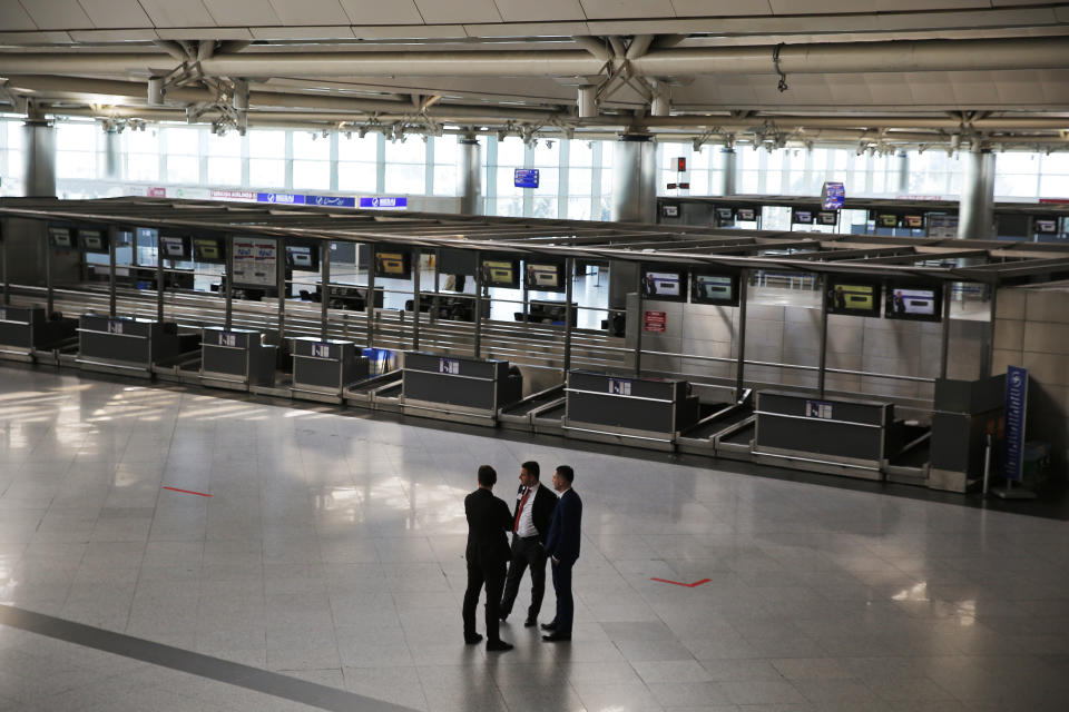 Security personnel of Ataturk International Airport, in Istanbul, stand in front of the empty check-in counters, Friday, April 5, 2019, ahead of its closure. The relocation from Ataturk International Airport to Istanbul Airport on the Black Sea shores— dubbed the "Great Move"—began early Friday and is expected to end Saturday. Ataturk Airport, ranked 17th busiest in the world in 2018 according to preliminary statistics, will cease commercial operations at 02:00 am local Saturday (2300 GMT Friday.) (AP Photo/Lefteris Pitarakis)