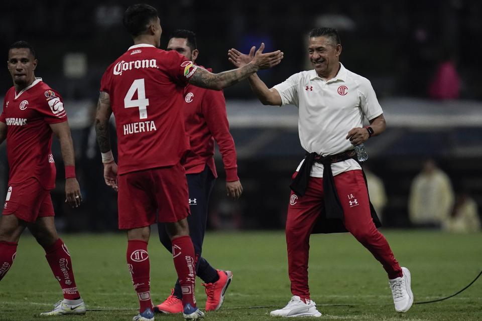 El técnico de Toluca Ignacio Ambriz (derecha) y Valber Huerta (4) celebran tras eliminar al América en las semifinales del torneo Apertura de México, el sábado 22 de octubre de 2022. (AP Foto/Eduardo Verdugo)