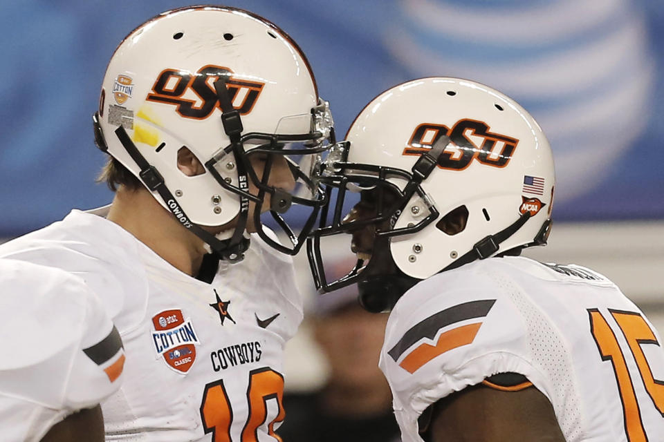 After scoring a touchdown against Missouri, Oklahoma State quarterback Clint Chelf (10) celebrates with wide receiver John Goodlett (15) during the second half of the Cotton Bowl NCAA college football game, Friday, Jan. 3, 2014, in Arlington, Texas. (AP Photo/Brandon Wade)